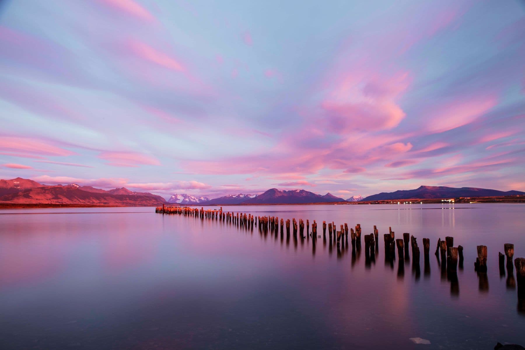 Soft pink sunset reflected over a calm lake
