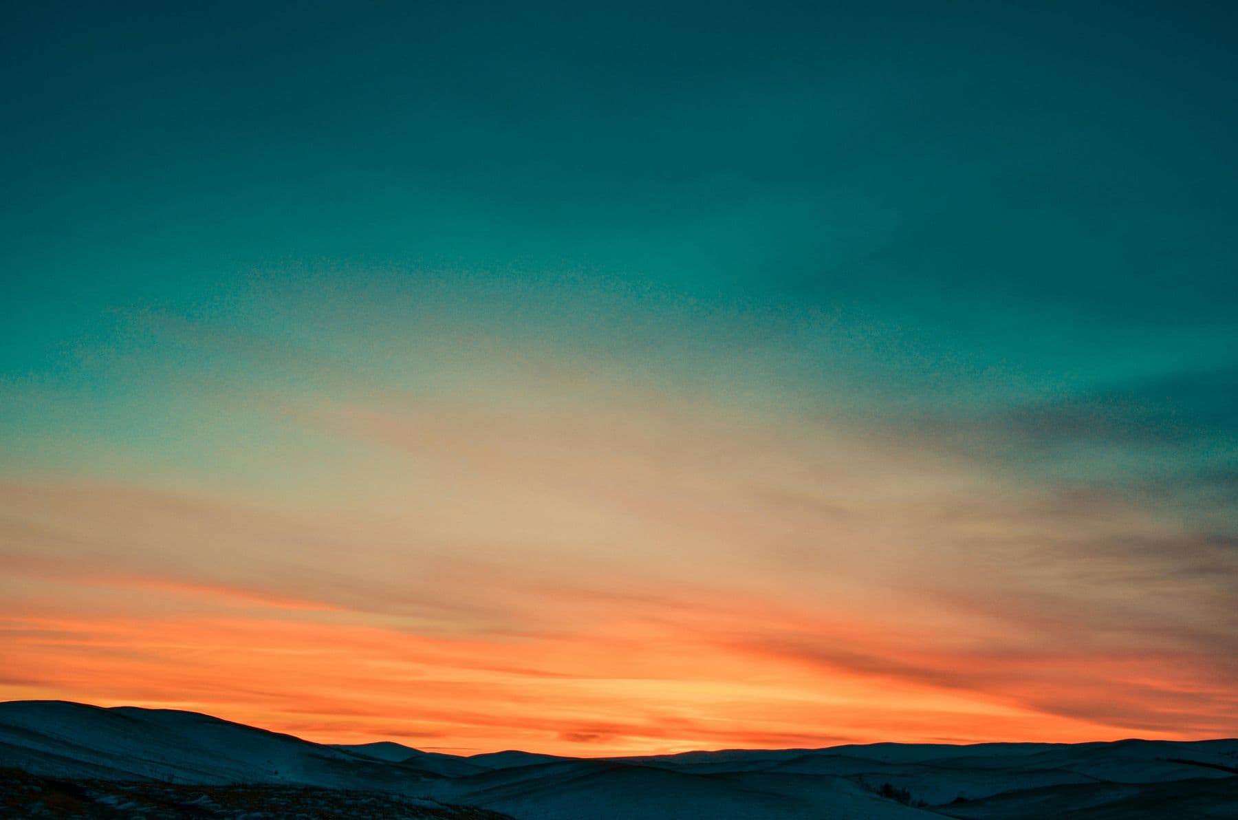 Teal and amber sky at sunset over the horizon