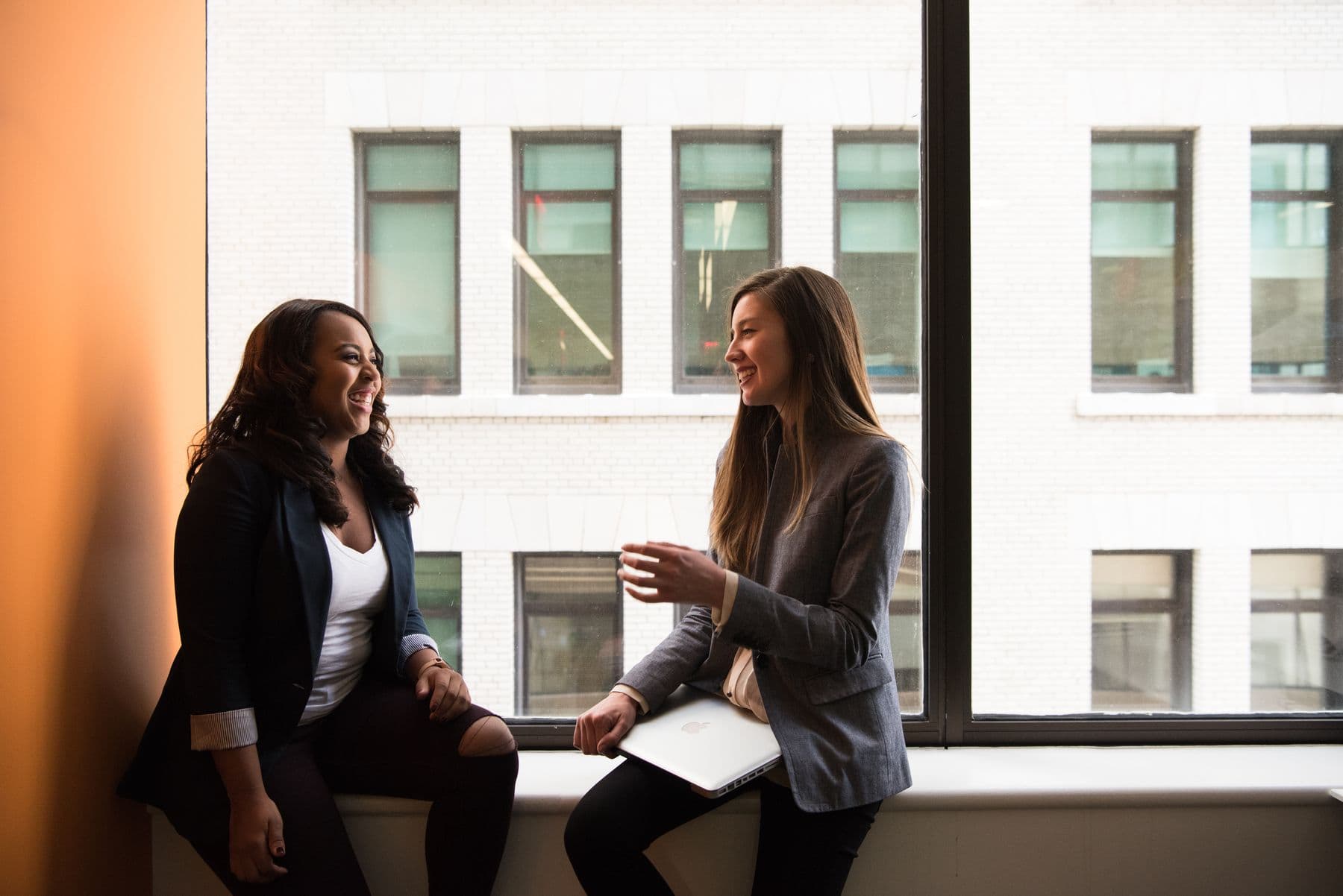 Two women in thoughtful conversation by a window