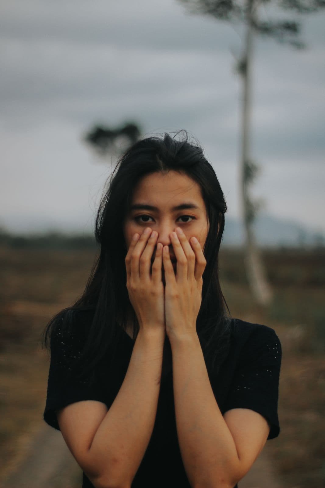Woman holding her hands over her face, overwhelmed by anxiety