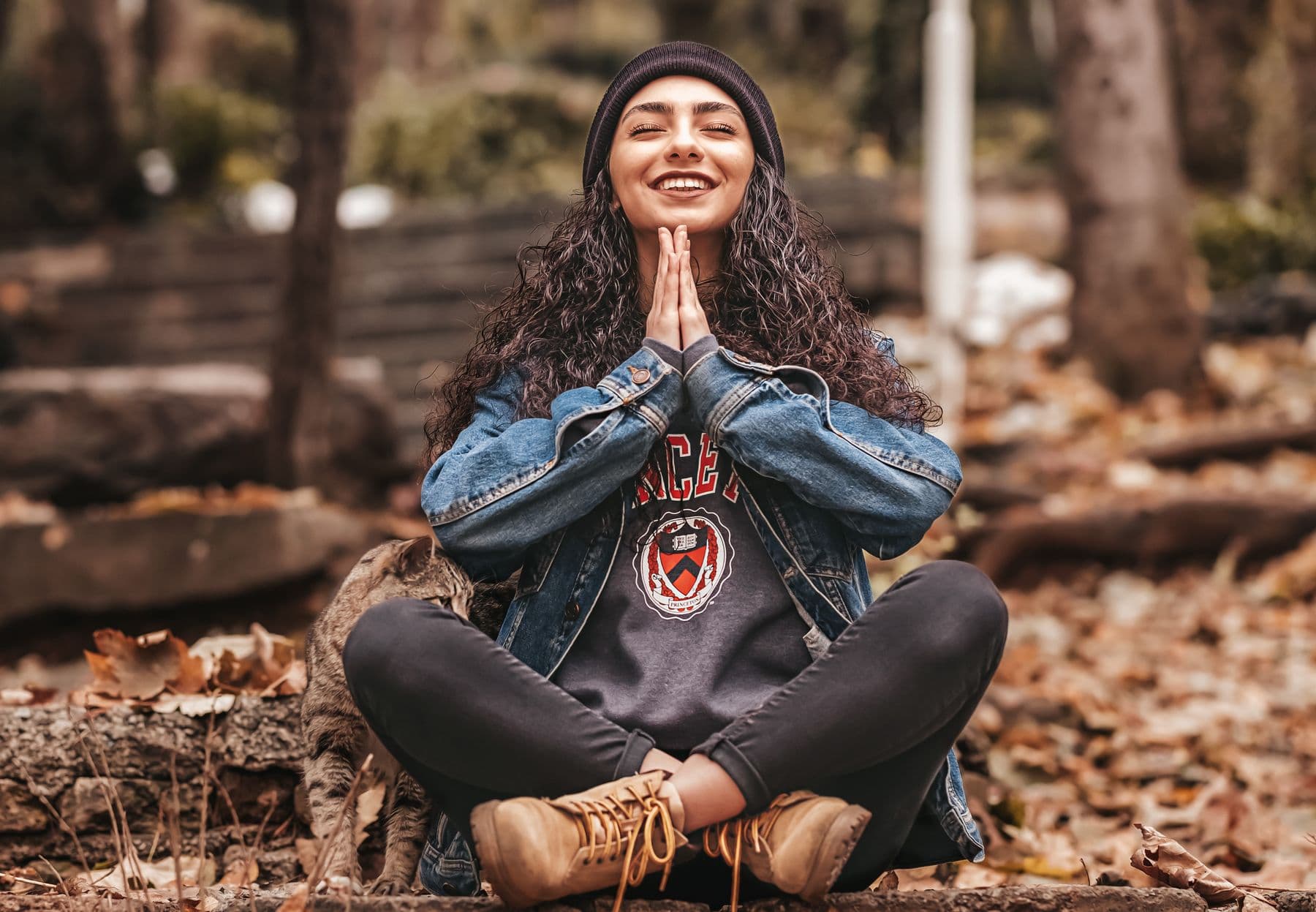 Woman meditating outdoors among autumn leaves