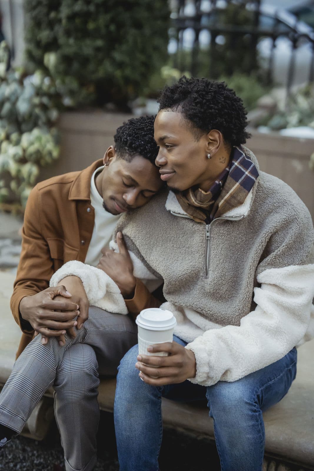 Two men in an affectionate embrace, sharing a quiet moment of intimacy