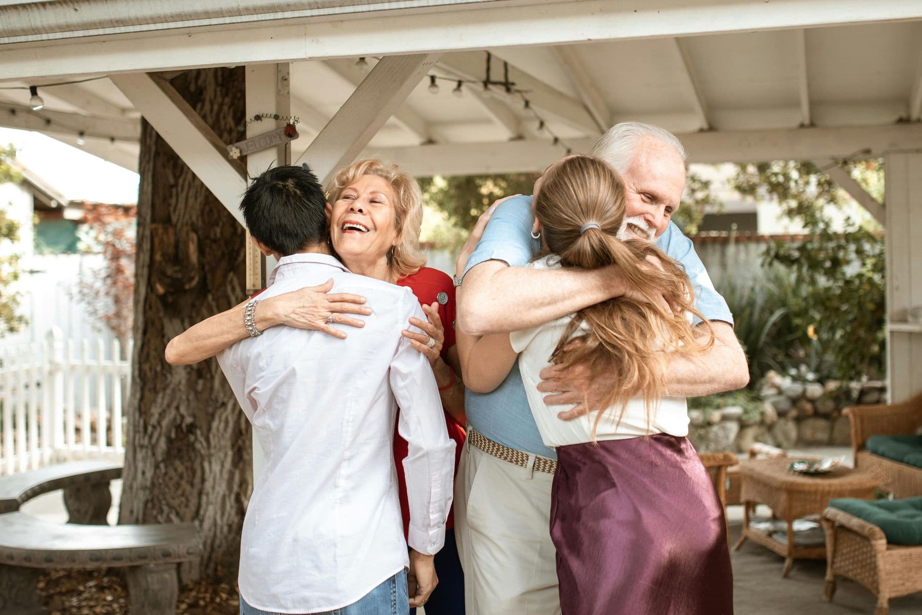 Adult family members hugging each other outdoors